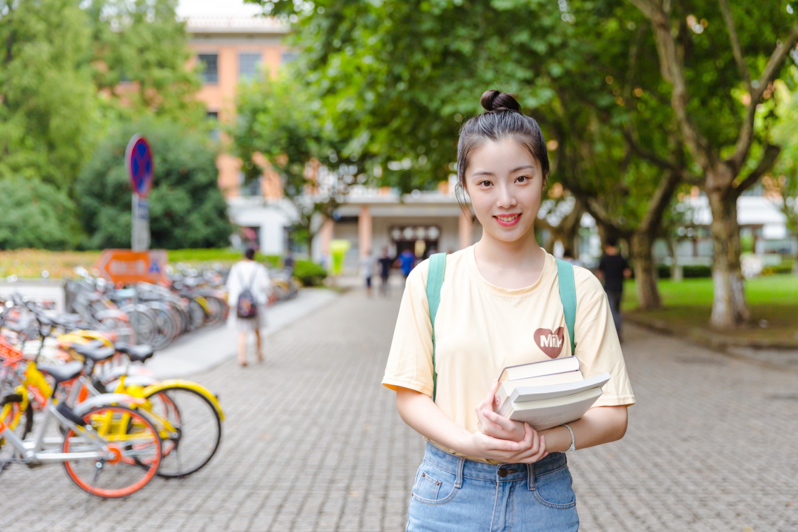 摄图网_500625605_banner_大学校园内女生抱着书本（企业商用）.jpg